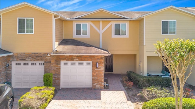 10124 Shadow Leaf Ct, Orlando, FL 32825 - multi unit property featuring stone siding, decorative driveway, stucco siding, and an attached garage