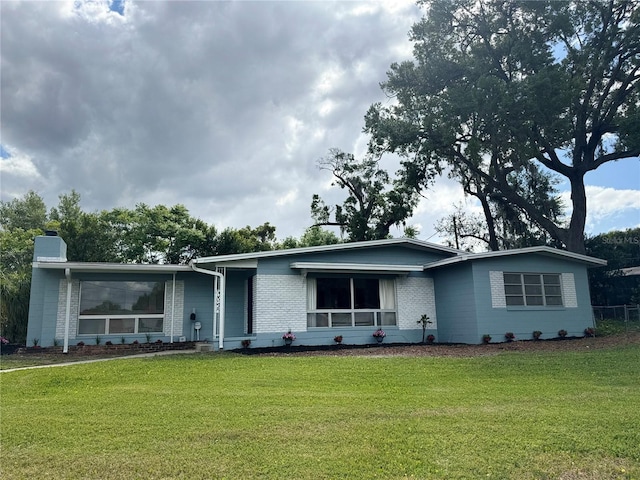 3107 Troy Dr, Orlando, FL 32806 - ranch-style home with a front yard, brick siding, and a chimney