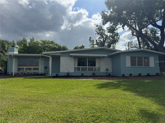 3107 Troy Dr, Orlando, FL 32806 - ranch-style house with brick siding, a front lawn, and a chimney