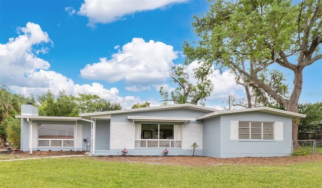 3107 Troy Dr, Orlando, FL 32806 - ranch-style home with a sunroom, a front yard, fence, brick siding, and a chimney