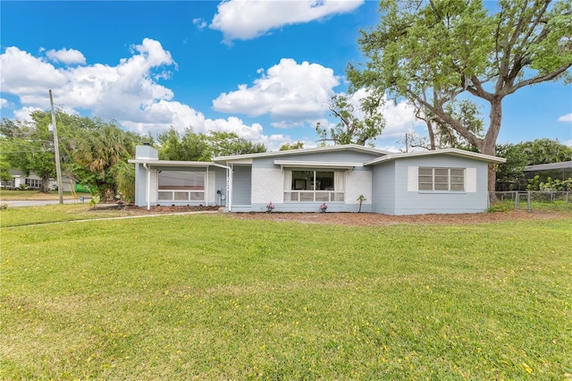 3107 Troy Dr, Orlando, FL 32806 - view of front facade with a chimney, fence, a front lawn, and brick siding