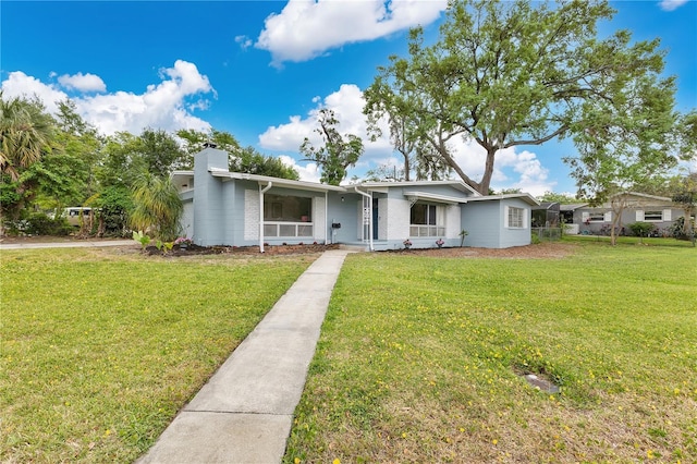 3107 Troy Dr, Orlando, FL 32806 - view of front of house featuring a front yard, brick siding, and a chimney