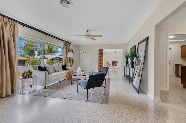 3107 Troy Dr, Orlando, FL 32806 - living area featuring visible vents, baseboards, light speckled floor, and ceiling fan