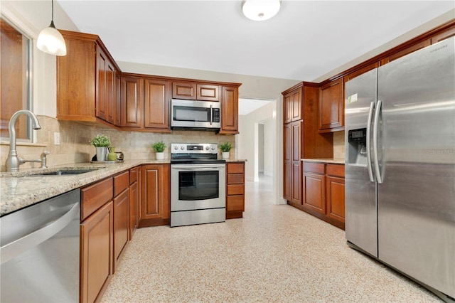 3107 Troy Dr, Orlando, FL 32806 - kitchen with a sink, brown cabinets, stainless steel appliances, decorative backsplash, and light stone counters