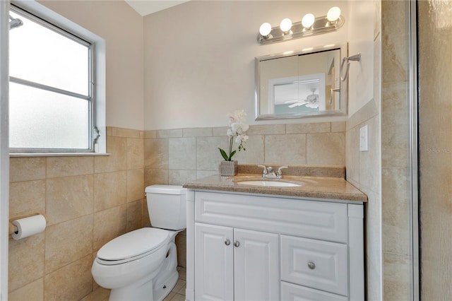 3107 Troy Dr, Orlando, FL 32806 - bathroom with toilet, tile walls, vanity, and wainscoting