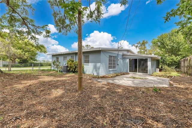 3107 Troy Dr, Orlando, FL 32806 - back of house with a sunroom, a patio area, central air condition unit, and fence