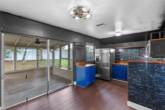 6031 W Ridgewood Ave, Orlando, FL 32835 - kitchen with wooden counters, blue cabinetry, appliances with stainless steel finishes, dark wood-style flooring, and ceiling fan
