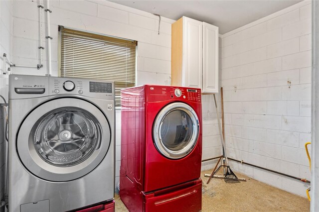 6031 W Ridgewood Ave, Orlando, FL 32835 - washroom featuring separate washer and dryer, concrete block wall, and cabinet space
