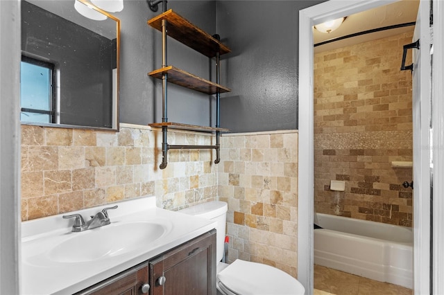 6031 W Ridgewood Ave, Orlando, FL 32835 - full bathroom featuring vanity, tile walls, shower / bathtub combination, tile patterned flooring, and a wainscoted wall