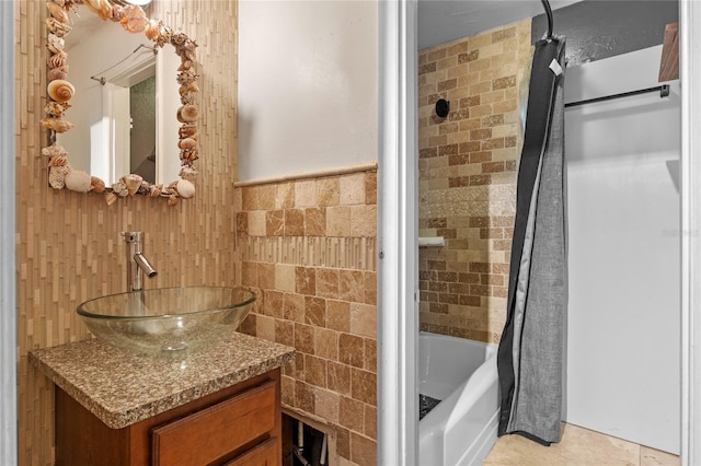 6031 W Ridgewood Ave, Orlando, FL 32835 - bathroom with shower / tub combo with curtain, vanity, tile walls, and a wainscoted wall