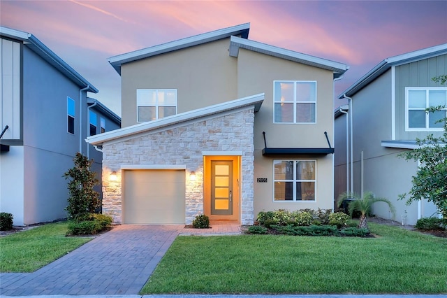 2805 Bookmark Dr, Kissimmee, FL 34746 - modern home with stone siding, stucco siding, a yard, and a garage
