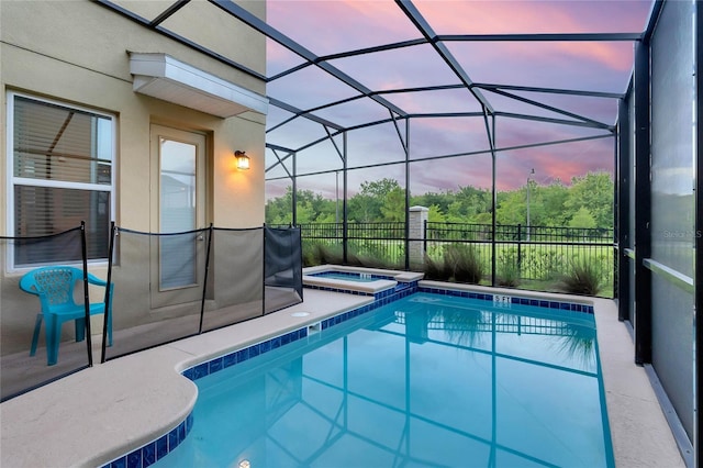 2805 Bookmark Dr, Kissimmee, FL 34746 - pool at dusk featuring a patio area, glass enclosure, and a pool with connected hot tub
