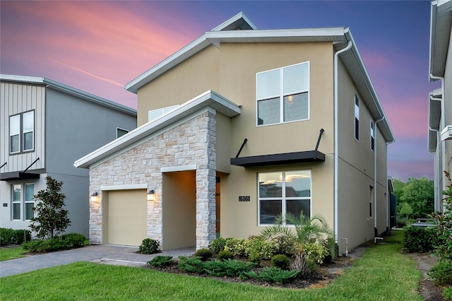 2805 Bookmark Dr, Kissimmee, FL 34746 - modern home with a front lawn, driveway, stone siding, an attached garage, and stucco siding