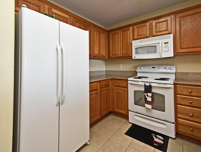 13427 Blue Heron Beach Dr Unit 1802, Orlando, FL 32821 - kitchen with brown cabinetry, light tile patterned floors, and white appliances