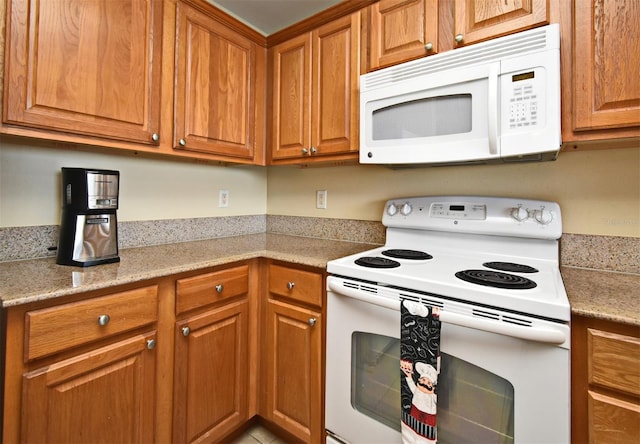 13427 Blue Heron Beach Dr Unit 1802, Orlando, FL 32821 - kitchen with brown cabinetry and white appliances