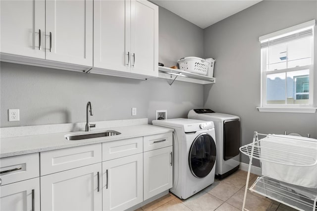 8384 Ludington Cir, Orlando, FL 32836 - laundry room featuring a sink, washing machine and clothes dryer, light tile patterned floors, baseboards, and cabinet space