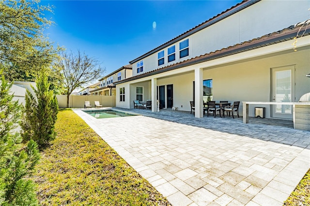 8384 Ludington Cir, Orlando, FL 32836 - rear view of property with stucco siding, a fenced backyard, outdoor dining space, and a patio area