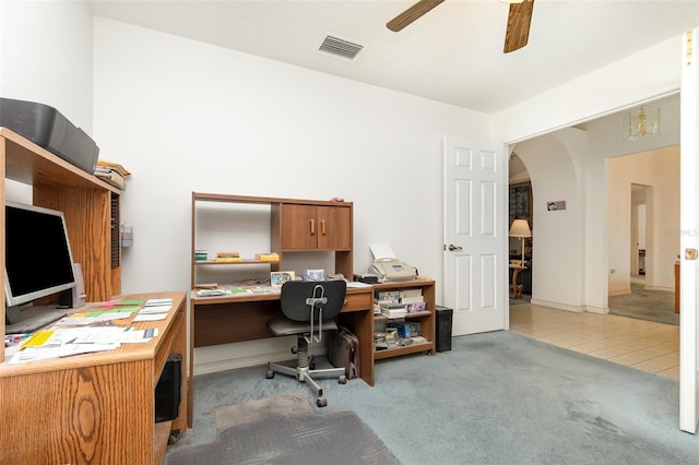 home office with carpet flooring, a ceiling fan, arched walkways, and visible vents