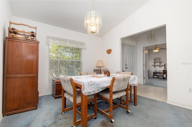 dining room with lofted ceiling, ceiling fan with notable chandelier, light tile patterned floors, and light carpet