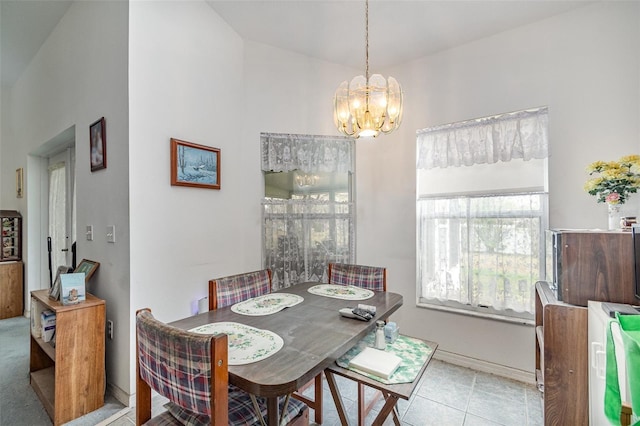 tiled dining area featuring baseboards and an inviting chandelier