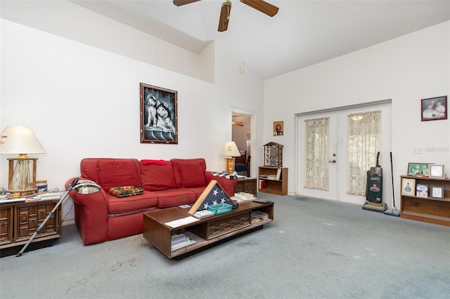 carpeted living area with high vaulted ceiling, ceiling fan, and french doors