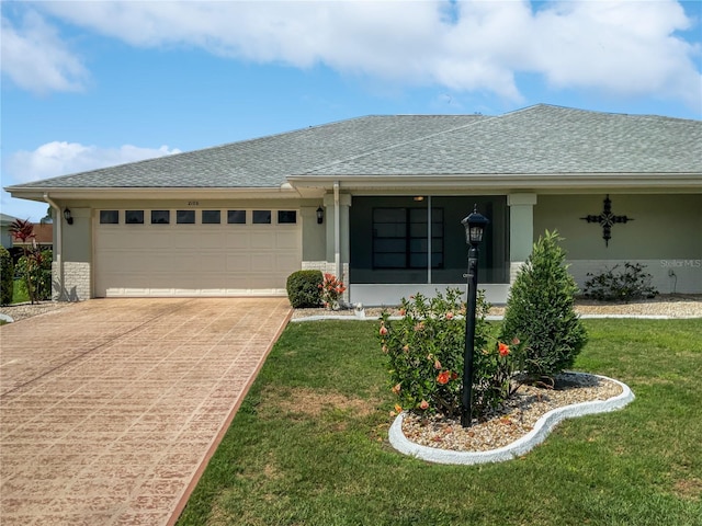 ranch-style house with stucco siding, an attached garage, a front lawn, and driveway