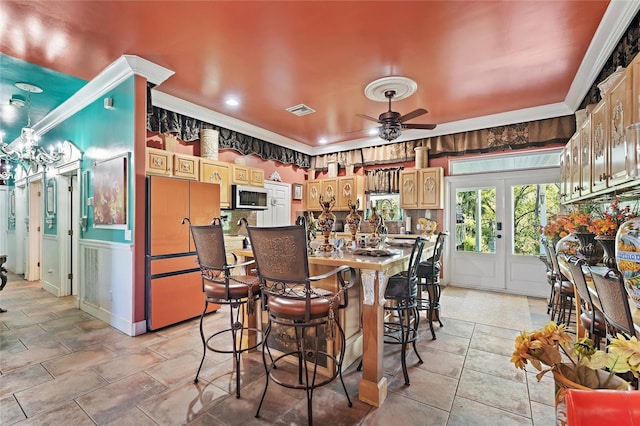dining space featuring ceiling fan, visible vents, and crown molding