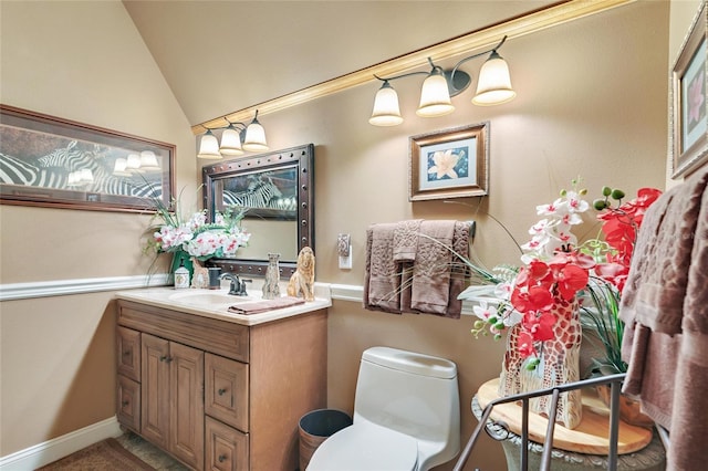 half bathroom featuring toilet, vanity, baseboards, and lofted ceiling