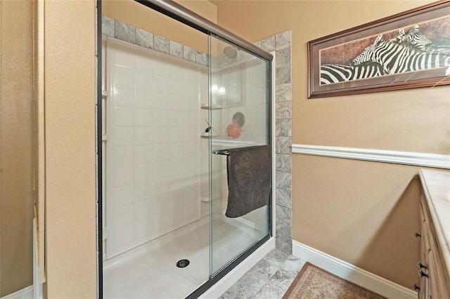 bathroom with baseboards and a shower stall