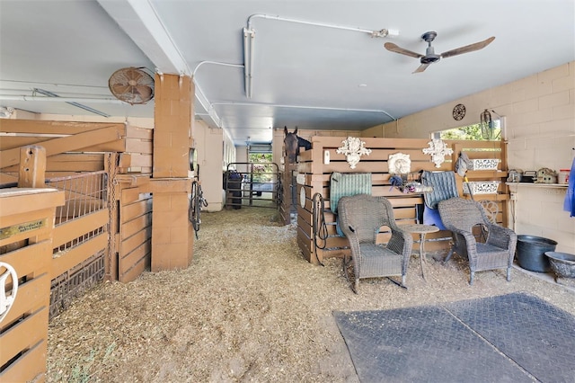 miscellaneous room with ceiling fan and concrete block wall