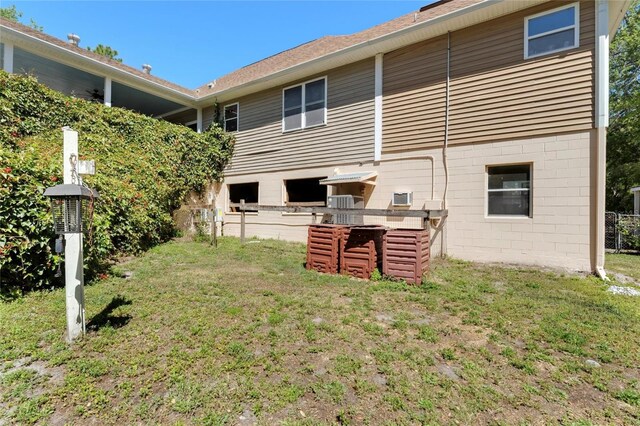 rear view of property featuring a lawn