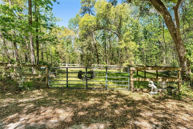 view of gate with a wooded view and fence
