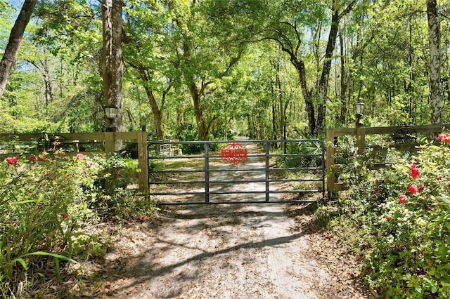 view of gate featuring a wooded view