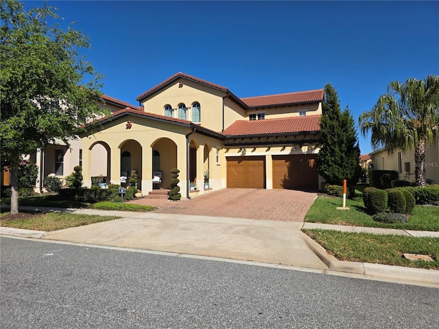 15149 Canoe Pl, Winter Garden, FL 34787 - mediterranean / spanish-style house with a tile roof, stucco siding, decorative driveway, a porch, and a garage