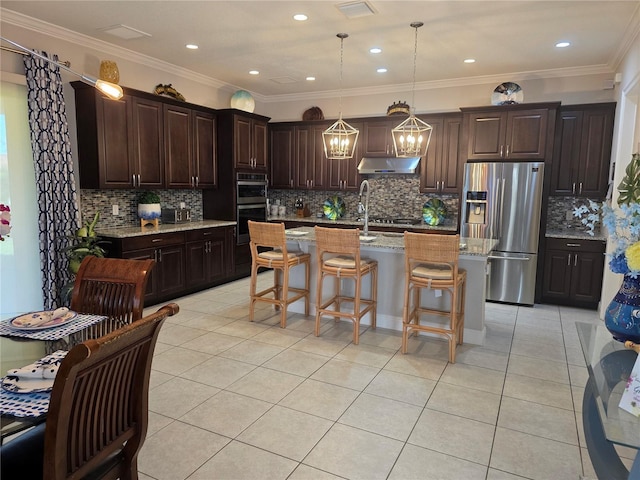 15149 Canoe Pl, Winter Garden, FL 34787 - kitchen featuring a chandelier, stainless steel appliances, under cabinet range hood, a kitchen breakfast bar, and light tile patterned floors