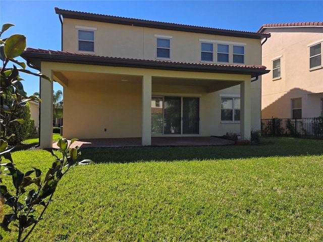 15149 Canoe Pl, Winter Garden, FL 34787 - rear view of house featuring a tiled roof, stucco siding, fence, and a lawn