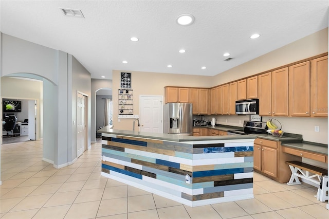 640 Brookfield Pl, Apopka, FL 32712 - kitchen with visible vents, dark countertops, appliances with stainless steel finishes, arched walkways, and light tile patterned floors