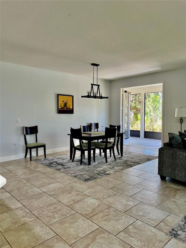 dining room featuring baseboards and a textured ceiling