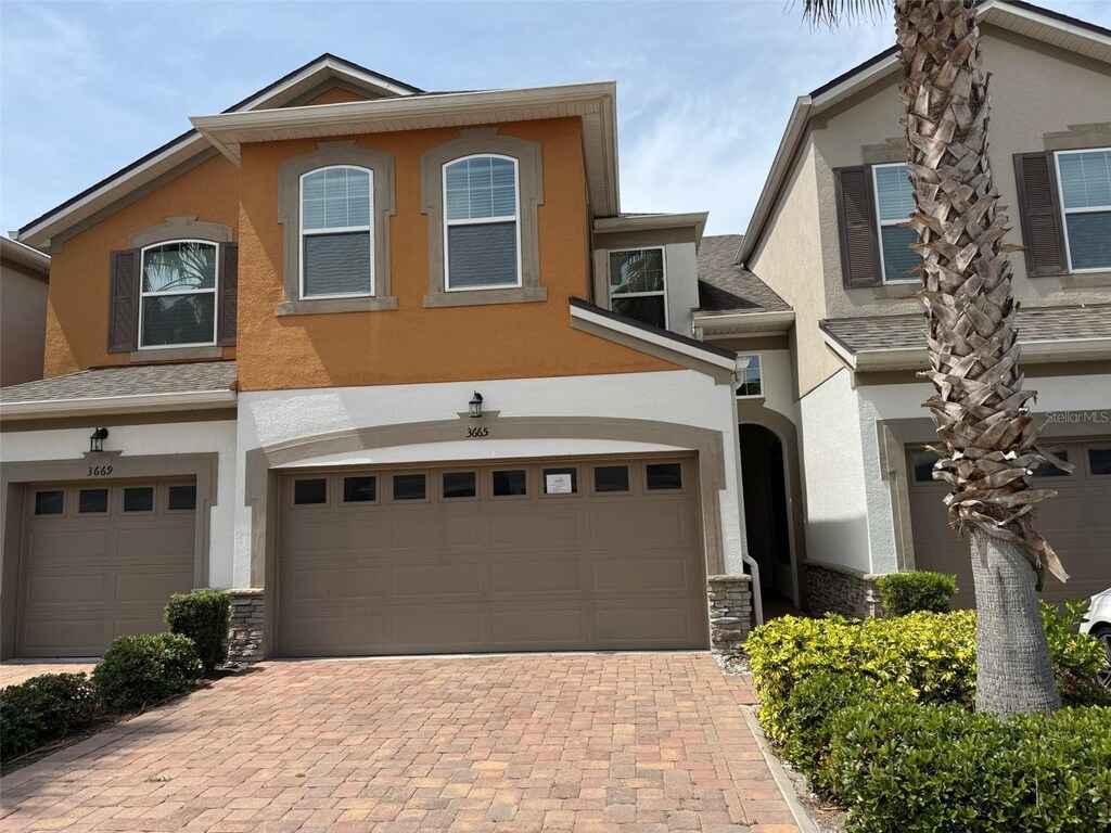 3665 Brighton Park Cir, Orlando, FL 32812 - view of front of house featuring decorative driveway, stucco siding, and an attached garage