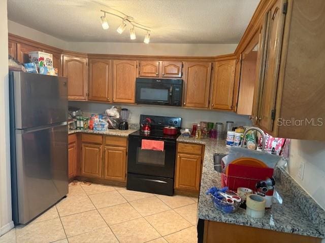 2108 Wolf Rd, Orlando, FL 32808 - kitchen featuring black appliances, brown cabinets, light tile patterned flooring, and stone counters