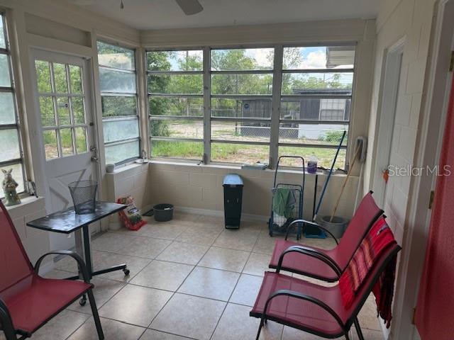 2108 Wolf Rd, Orlando, FL 32808 - unfurnished sunroom featuring a ceiling fan