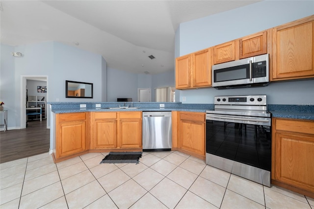 654 Chadbury Way, Kissimmee, FL 34744 - kitchen featuring vaulted ceiling, a sink, a peninsula, light tile patterned floors, and stainless steel appliances