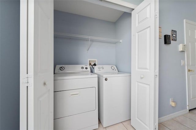 654 Chadbury Way, Kissimmee, FL 34744 - clothes washing area with light tile patterned floors, baseboards, washer and dryer, and laundry area