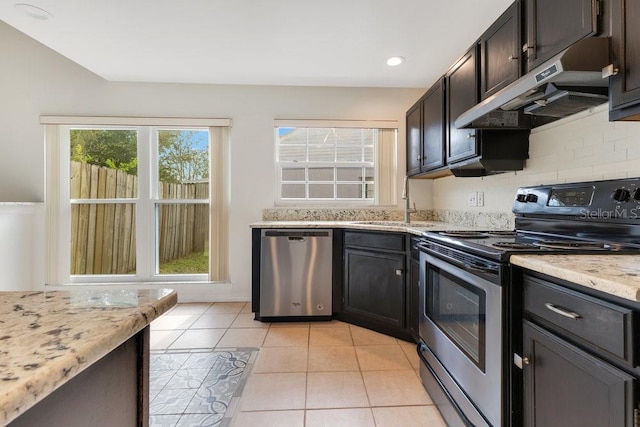 1002 Kelsey Ave, Oviedo, FL 32765 - kitchen with decorative backsplash, stainless steel appliances, under cabinet range hood, a sink, and light tile patterned floors