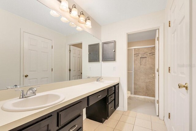 1002 Kelsey Ave, Oviedo, FL 32765 - bathroom with toilet, a sink, double vanity, and tile patterned flooring