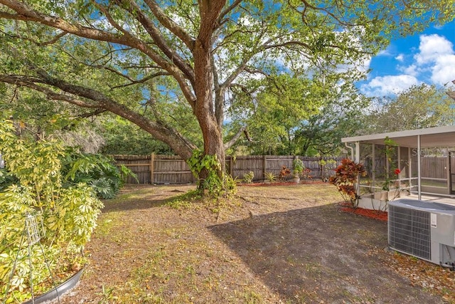 1002 Kelsey Ave, Oviedo, FL 32765 - view of yard with central AC unit, a patio area, a fenced backyard, and a sunroom