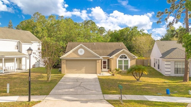 1002 Kelsey Ave, Oviedo, FL 32765 - view of front of property featuring concrete driveway, stucco siding, fence, a front lawn, and a garage