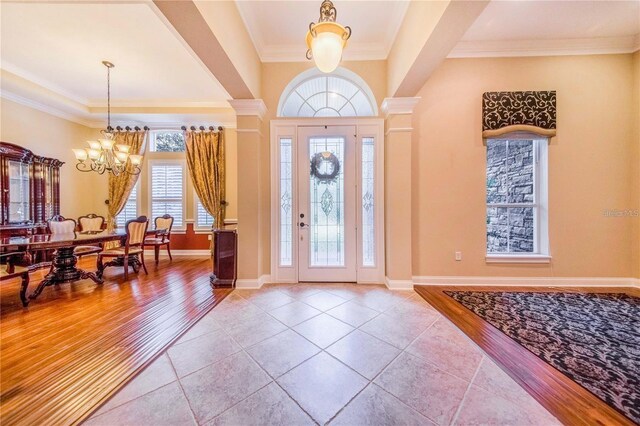 25813 Feather Ridge Ln, Sorrento, FL 32776 - foyer entrance featuring a chandelier, crown molding, light wood finished floors, and baseboards