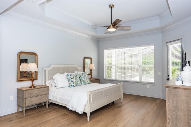 25813 Feather Ridge Ln, Sorrento, FL 32776 - bedroom featuring light wood finished floors, a tray ceiling, multiple windows, baseboards, and crown molding