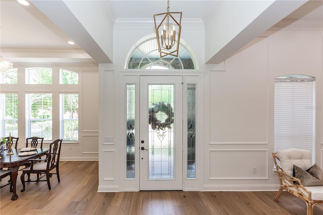 25813 Feather Ridge Ln, Sorrento, FL 32776 - entryway with a chandelier, a decorative wall, wood finished floors, and ornamental molding